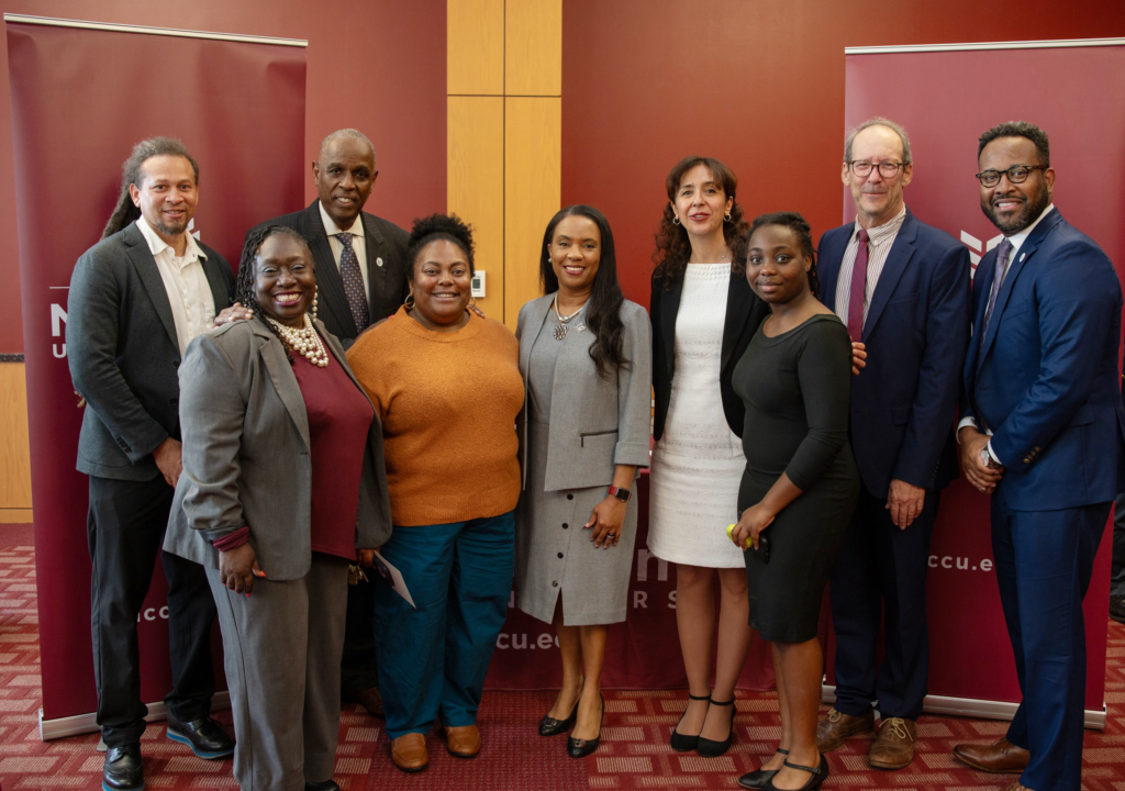 NCCU and Wilmette Institute teams with students standing together posing for photo in same room as signing happened